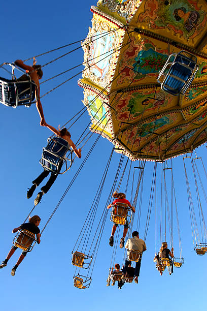 People ride a chairoplane in an amusement park stock photo