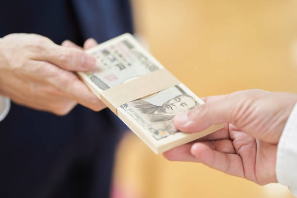 a man in a suit handing over money - moeda japonesa imagens e fotografias de stock