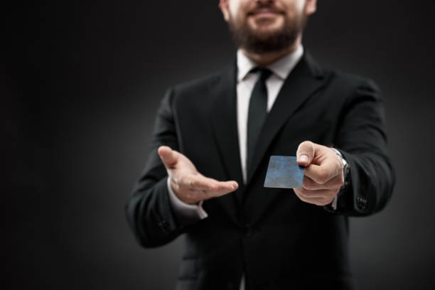 istock Man in suit holding and offering credit card 1334775565