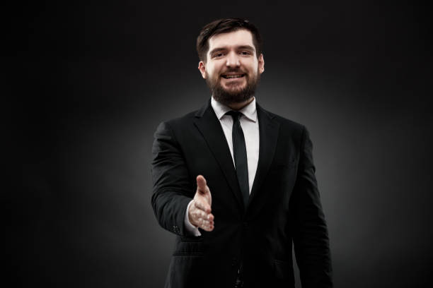 istock Businessman holding hand, ready for handshake 1334775580