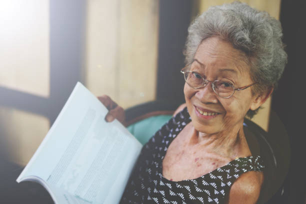 Portrait of Asian Senior retirement woman smile with casual clothing in home happy lifestyle. Elderly Grandma. Southeast Asia Ethnicity Good Healthy.Reading book color retro style copy space. retrato de la anciana jubilada senior asiática sonríe con ropa casual en el estilo de vida feliz en casa. abuela anciana. etnicidad del sudeste asiático . buena salud. espacio de copia de estilo retro de color de lectura de libro. estilo retro de color