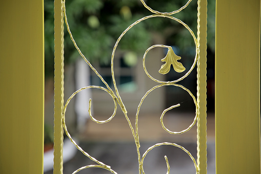 Part of the gate is made of forged metal with patterns, painted black photo