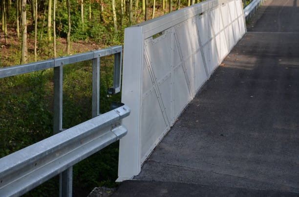 istock path for cyclists with an asphalt surface. galvanized iron railing over road barriers. Bridge railing with tilting to the sides. railing made of perforated sheet metal in the shape of a triangle 1334781245