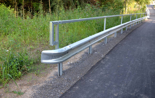 istock path for cyclists with an asphalt surface. galvanized iron railing over road barriers. Bridge railing with tilting to the sides. railing made of perforated sheet metal in the shape of a triangle 1334781287