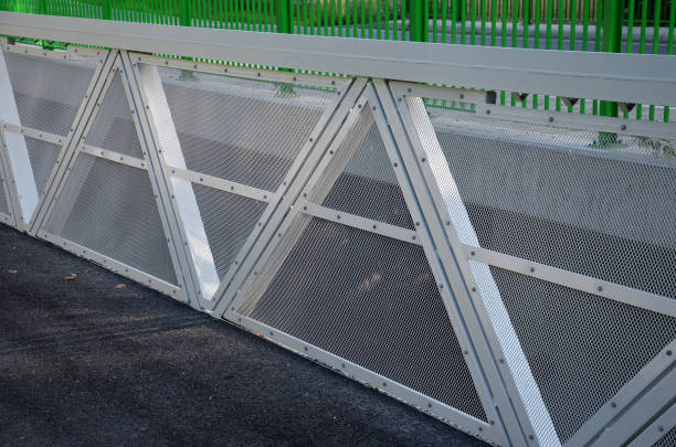 istock path for cyclists with an asphalt surface. galvanized iron railing over road barriers. Bridge railing with tilting to the sides. railing made of perforated sheet metal in the shape of a triangle 1334781289