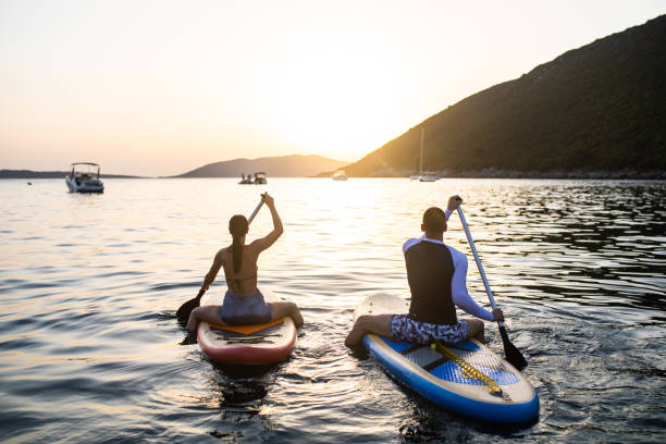 istock A young couple standup paddle boarding at sunset 1334782135