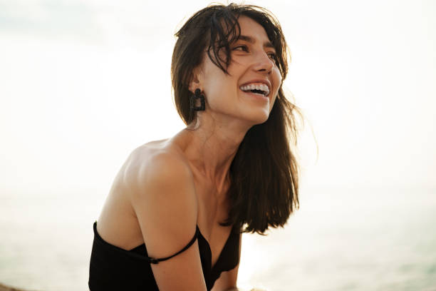 istock Young smiling woman outdoors portrait at beach 1334783154