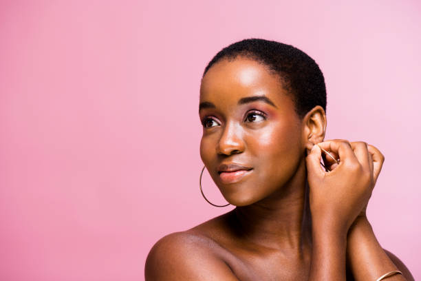 istock Smiling young woman adjusting gold hoop earring 1334785225