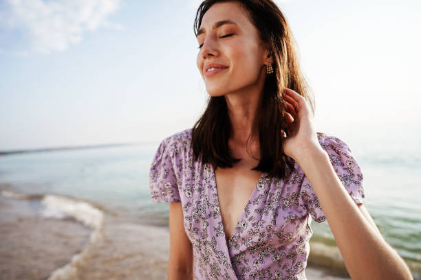 istock Happy woman on the beach walking by seaside 1334785365