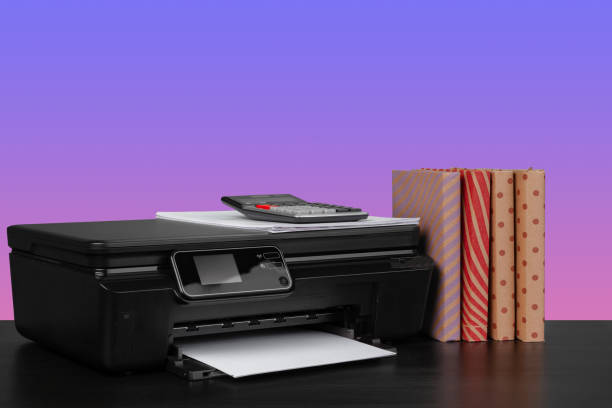 istock Home laser printer on desk against purple background 1334786116