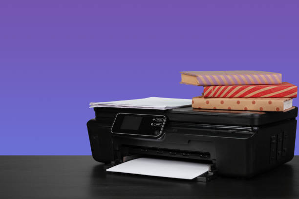 istock Home laser printer on desk against purple background 1334786189