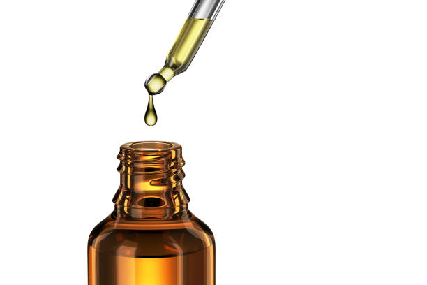 une goutte d’huile cosmétique s’égoutte dans un bocal en verre ambré. rendu 3d. - huile de massage photos et images de collection