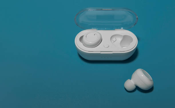 istock White wireless headphones with charger on blue background 1334789156