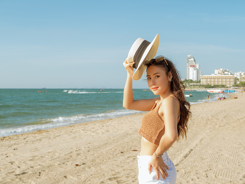 woman wearing white short standing on the beach with sunny day