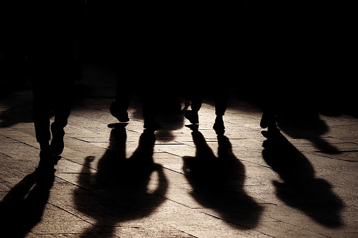 Black shadows and silhouettes of people on the street