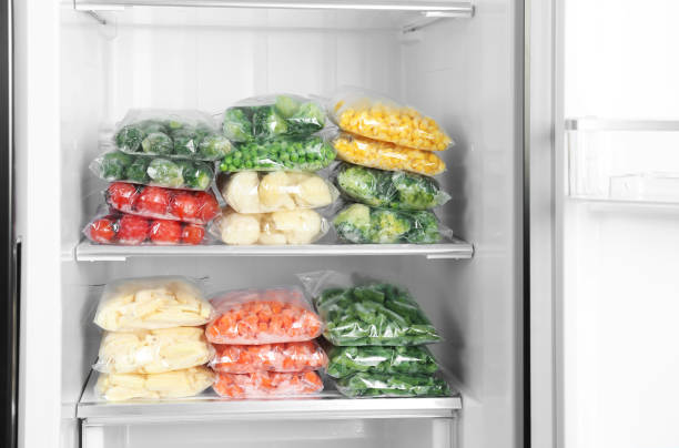istock Plastic bags with different frozen vegetables in refrigerator 1334791245