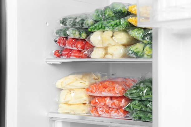 istock Plastic bags with different frozen vegetables in refrigerator 1334791552