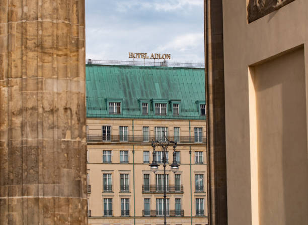 Berlin, Germany - August 9, 2021: View through the pillars from the  Brandenburger Tor to Hotel Adlon. Hotel with a long history.