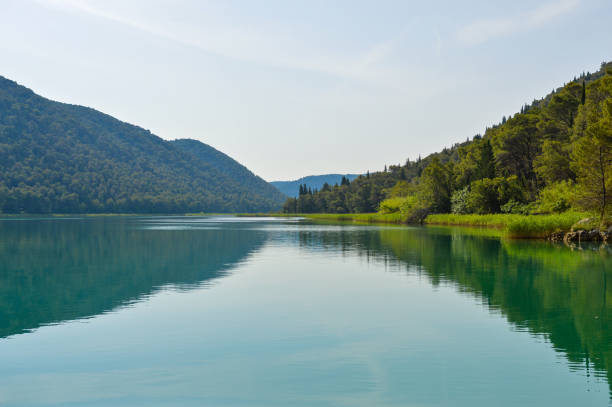 istock Beautiful Krka river scene with calm water and reflection 1334796853