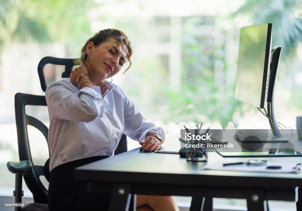 Businesswoman Having Neck Ache Due To Work Over Load And Bad Posture Pain Stock Photo