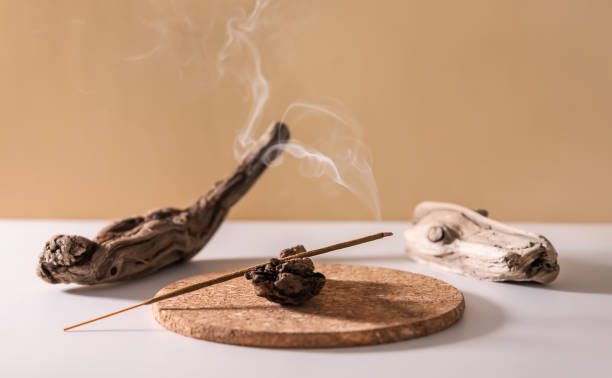Burning aromatic incense stick for yoga meditation and relaxing Burning aromatic incense stick for yoga meditation and relaxing on wooden minimalistic background. Aromatherapy smoke. incense photos stock pictures, royalty-free photos & images