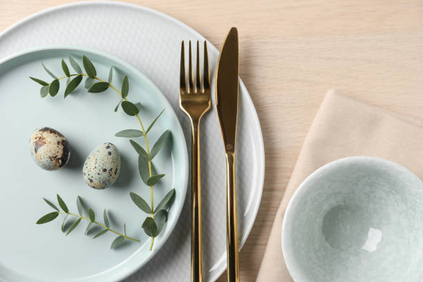 istock Festive Easter table setting with quail eggs on wooden background, flat lay. 1334801970
