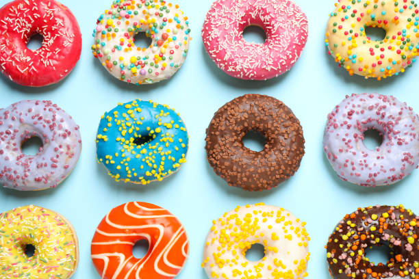 istock Delicious glazed donuts on light blue background, flat lay 1334802620