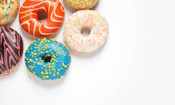 istock Delicious glazed donuts on white background, flat lay. Space for text 1334802867