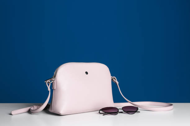 istock Stylish woman's bag and sunglasses on white table. Space for text 1334802928