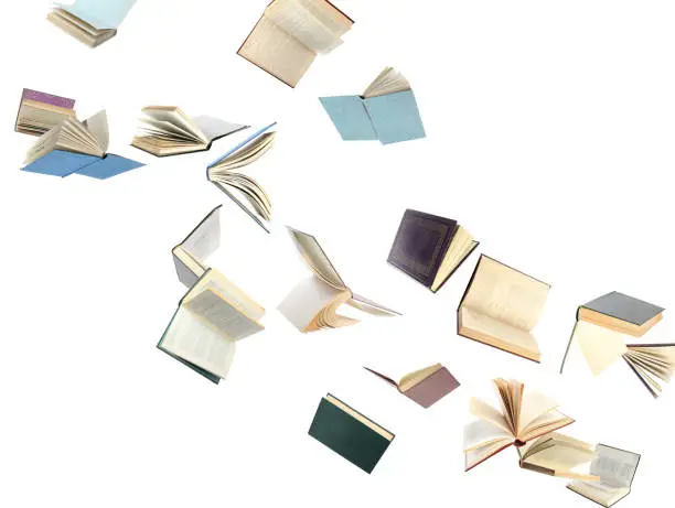 Photo of Old hardcover books flying on white background