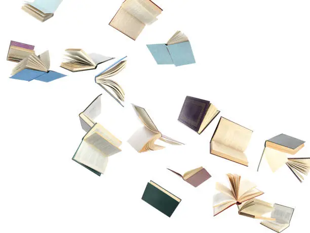 Old hardcover books flying on white background