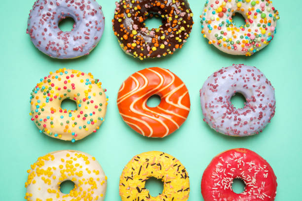 istock Delicious glazed donuts on turquoise background, flat lay 1334803022