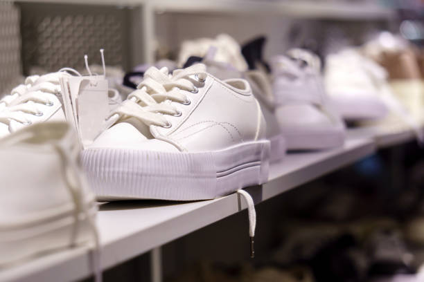 istock White sneakers on a white closet shelf. Selective focus. Buying shoes 1334804136