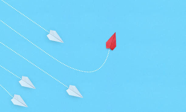 istock Business for new ideas creativity, innovative and solution concepts. Group of white paper plane in one direction and one red paper plane pointing in different way on blue background 1334805095