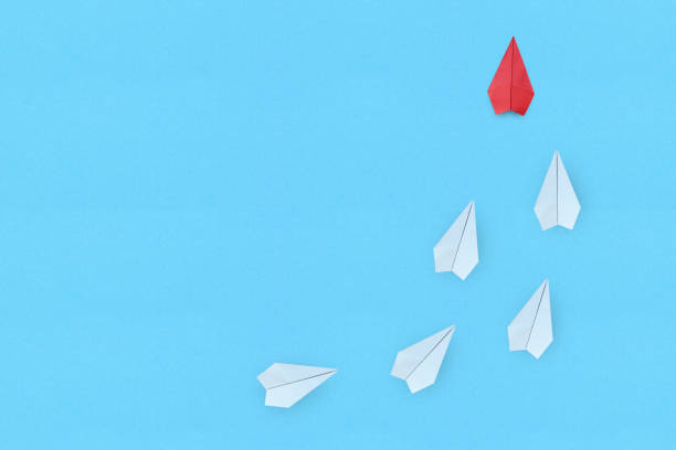 istock Leadership concept with red paper plane leading among white on blue background 3 1334807275