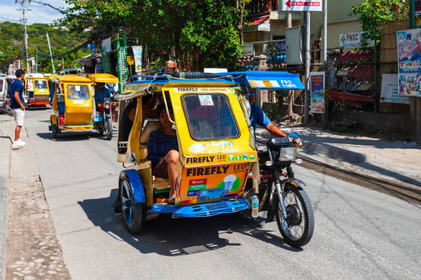 Tricycle is a popular transport in Philippines BORACAY, PHILIPPINES - MARCH 04, 2013: Tricycle at the main street in Boracay island. Tricycle is a very popular public taxi transport in Philippines. philippines tricycle stock pictures, royalty-free photos & images
