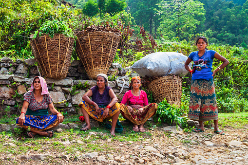 POKHARA, NEPAL - MAY 26, 2012: Unidentified nepalese women farmers have a rest after working in a rice field near Pokhara city in Nepal