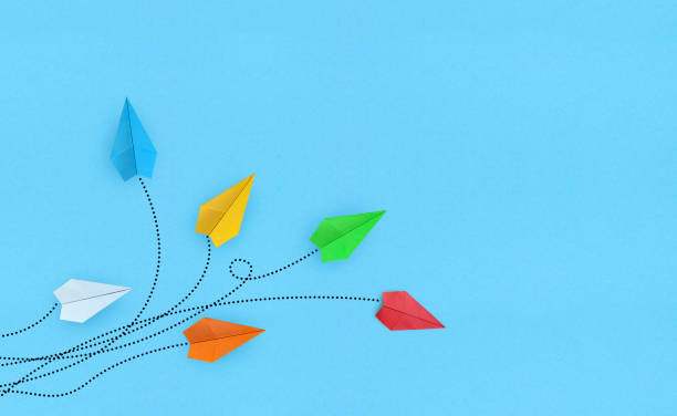 istock Color paper airplanes on blue background 1334808723