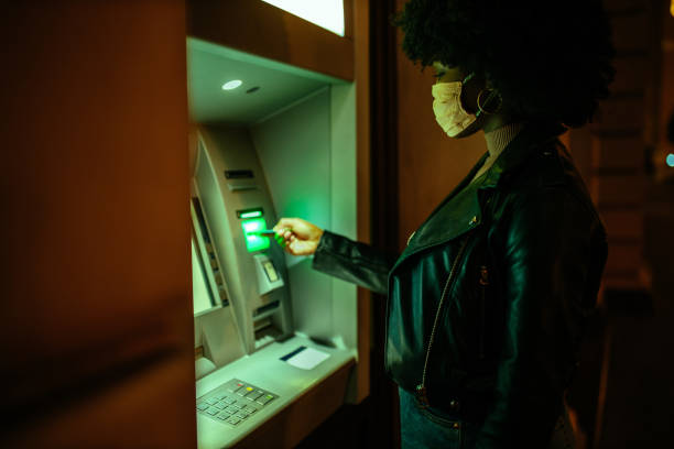 istock Afro woman making a transaction at an ATM 1334812107