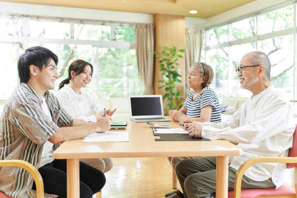 jeune couple et vieux couple parlant avec le sourire - chinese ethnicity aging process family asian ethnicity photos et images de collection