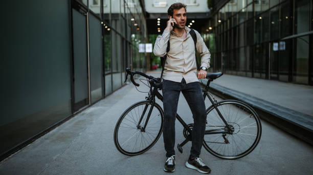 istock Handsome man with bike using smartphone 1334816724