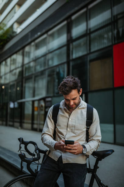 istock Man using phone while out in the city with bike 1334816728