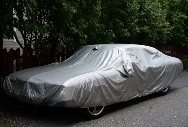 istock car fully covered with a silver cover, outdoor 1334817679