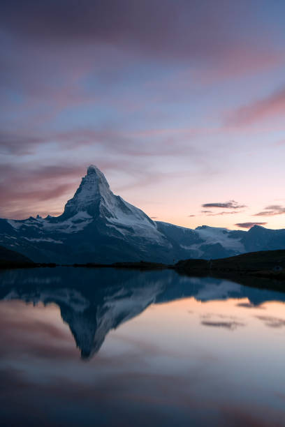 istock the Matterhon reflected in the Stellisee lake at sunset with colored clouds  vertical view - Zermatt - Switzerland 1334820482