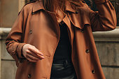 Cropped figure of young woman wearing stylish brown overcoat Street casual autumn concept.