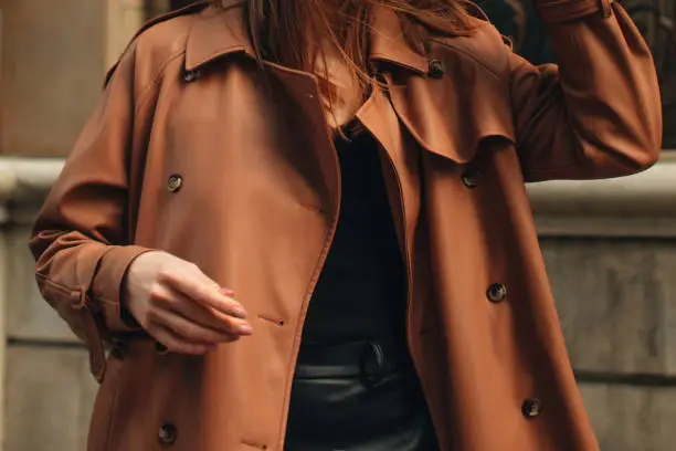 Photo of Cropped figure of young woman wearing stylish brown overcoat Street casual autumn concept.