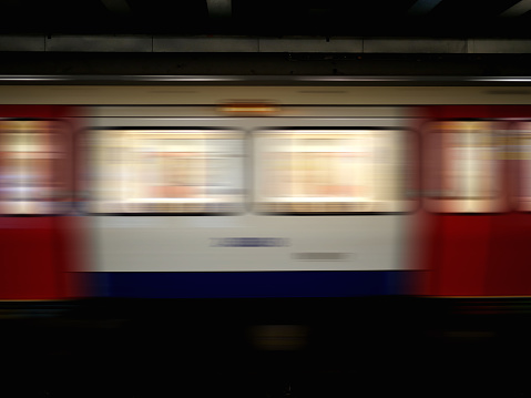 Long exposure shot of a speeding train in the underground at night.  Motion blur shot of an underground train showing windows and doors.
