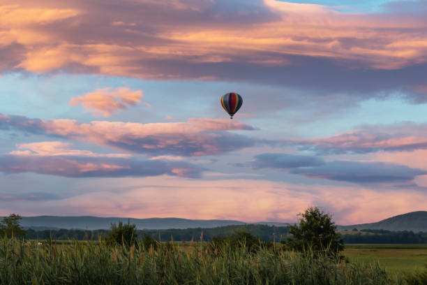 balão de ar quente sobre o campo ao nascer do sol com céu incrível - city of sunrise fotos - fotografias e filmes do acervo