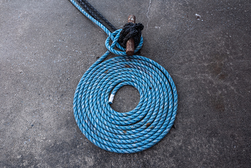 Blue mooring rope laid down in a spiral.