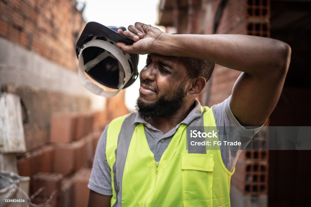 Exhausted construction worker at construction site Exhausted construction worker Heat - Temperature Stock Photo